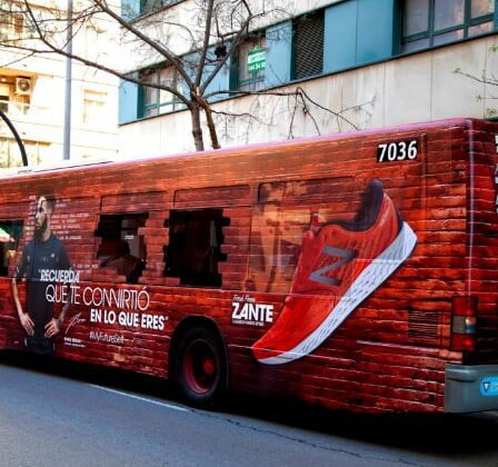 Imagen de un autobús rotulado con la publicidad de una marca deportiva con el eslogan "Recuerda que te convirtió en lo que eres"