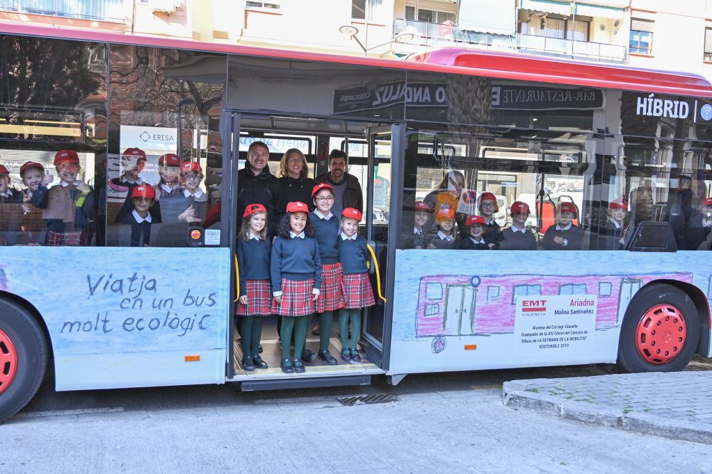 Imagen del autobús rotulado con los dibujos de escolares donde se lee "Viatja en un bus molt acologic"