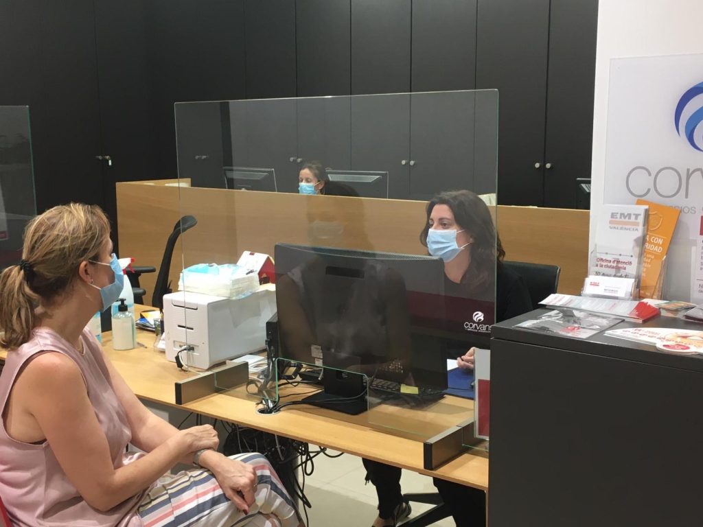 Imagen de trabajadora y clienta en la oficina de atención a la ciudadanía con las protecciones necesarias frente al covid